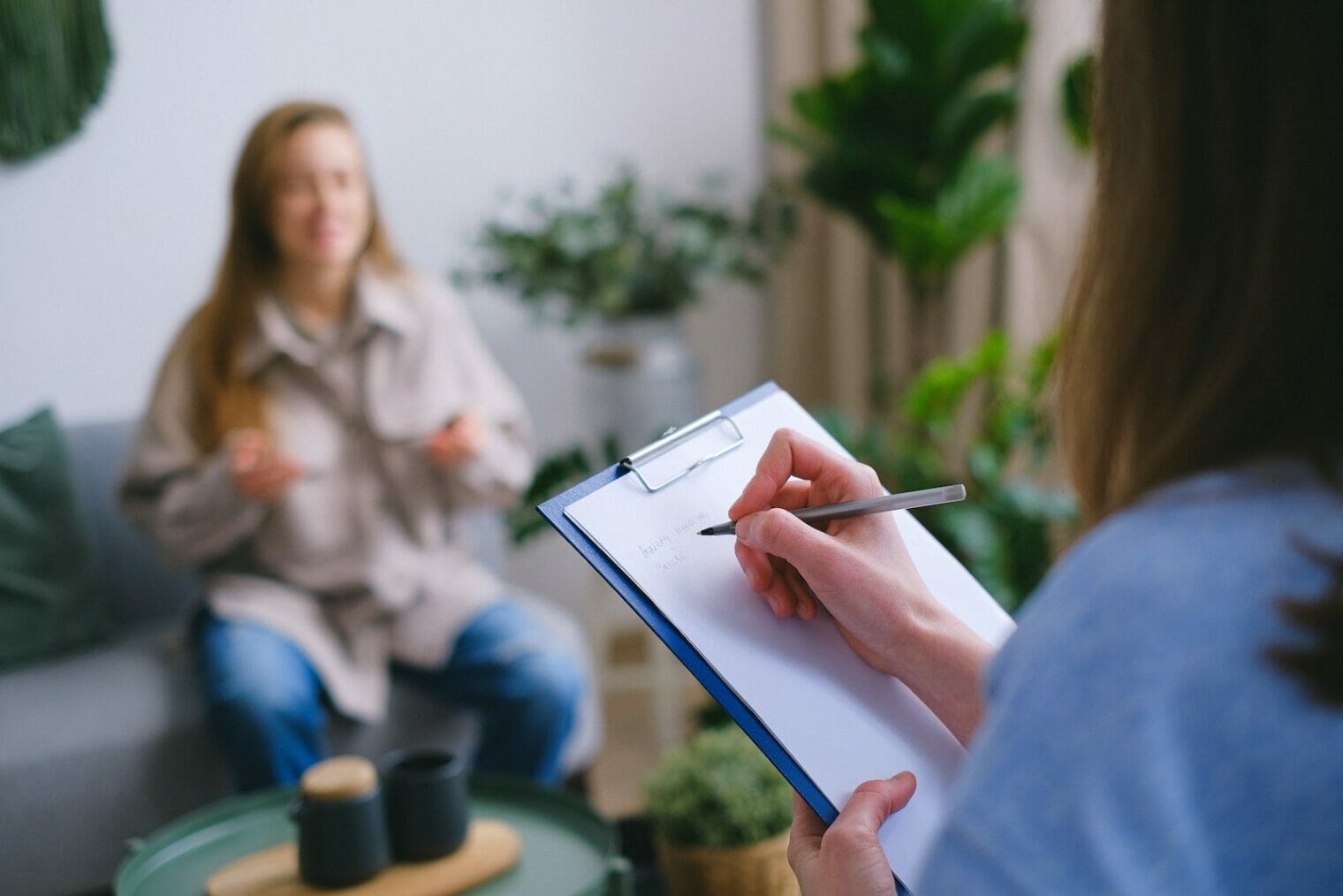 A woman is conducting behavior therapy sessions with a clipboard in front of her.