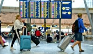 A group of third culture kids walking through an airport with luggage, experiencing the ultimate international cross culture.